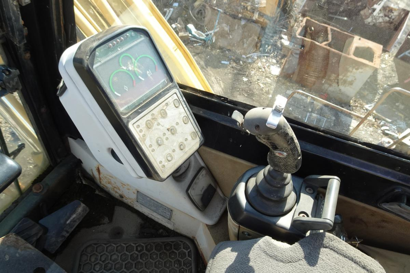Caterpillar 330L MH cab interior showing joystick control and instrument panel with gauges.