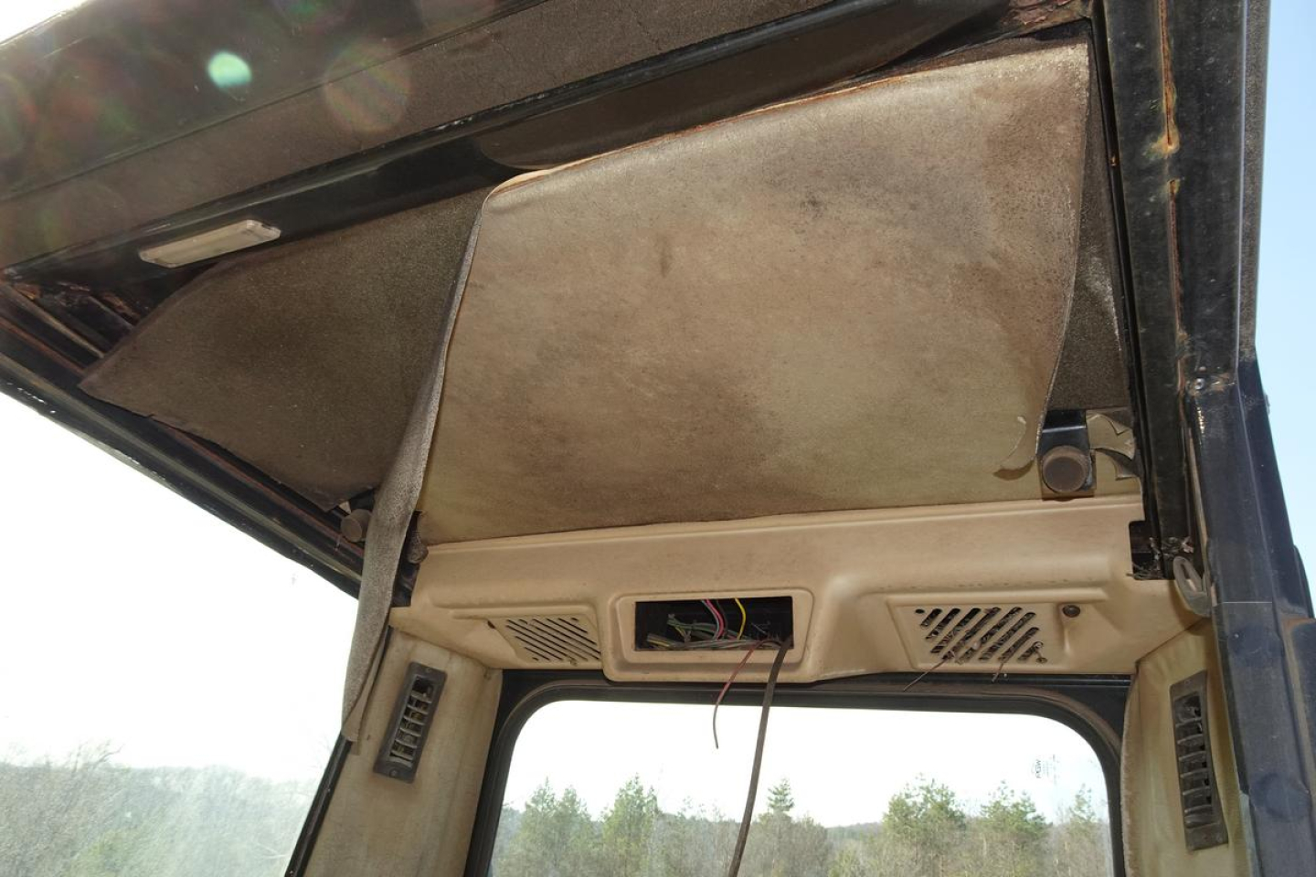 Caterpillar 330L MH cabin interior showing headliner and sun visor area.