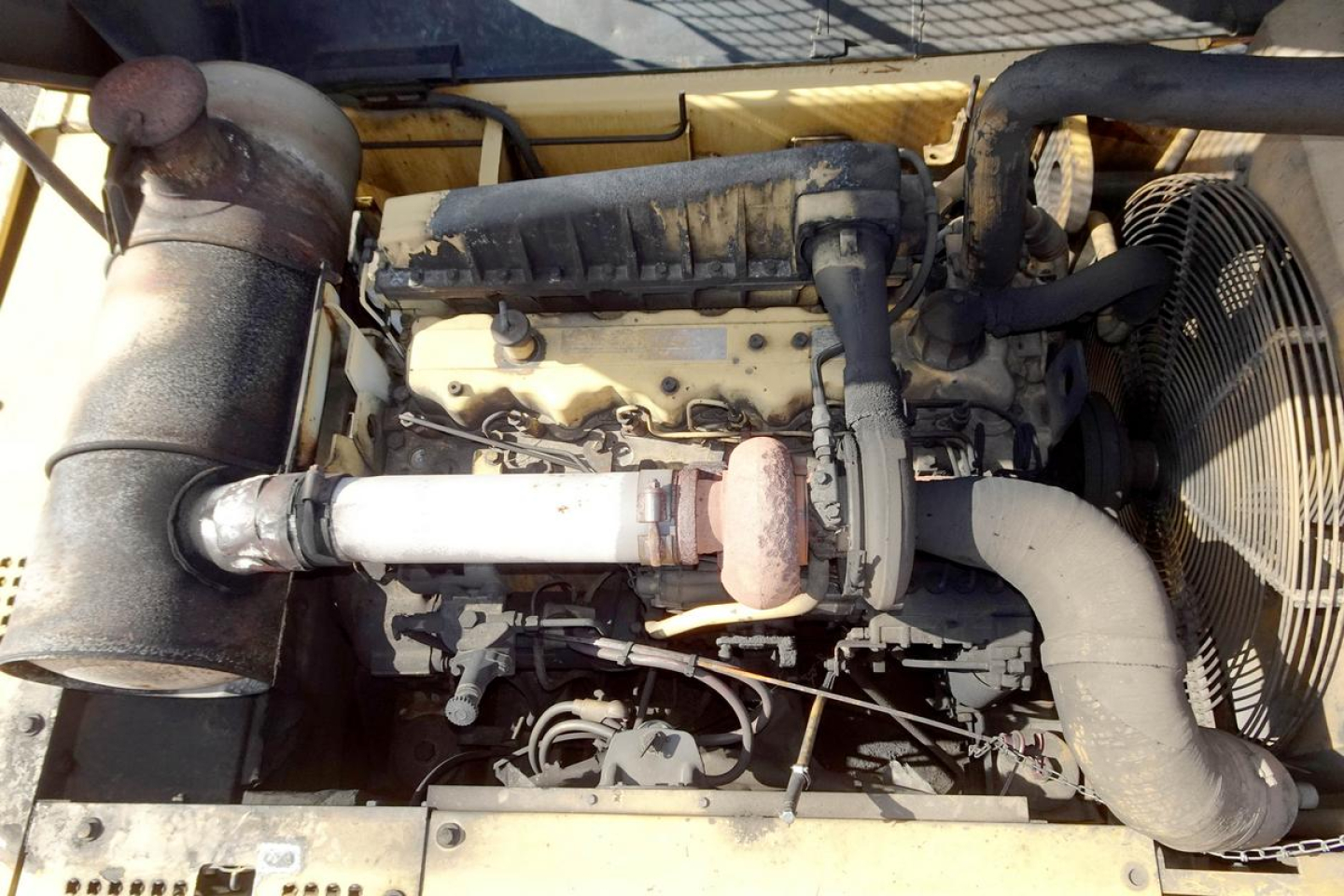 Caterpillar 330L MH engine bay showing intake, turbocharger, radiator fan, and exhaust system in a used trucking equipment.