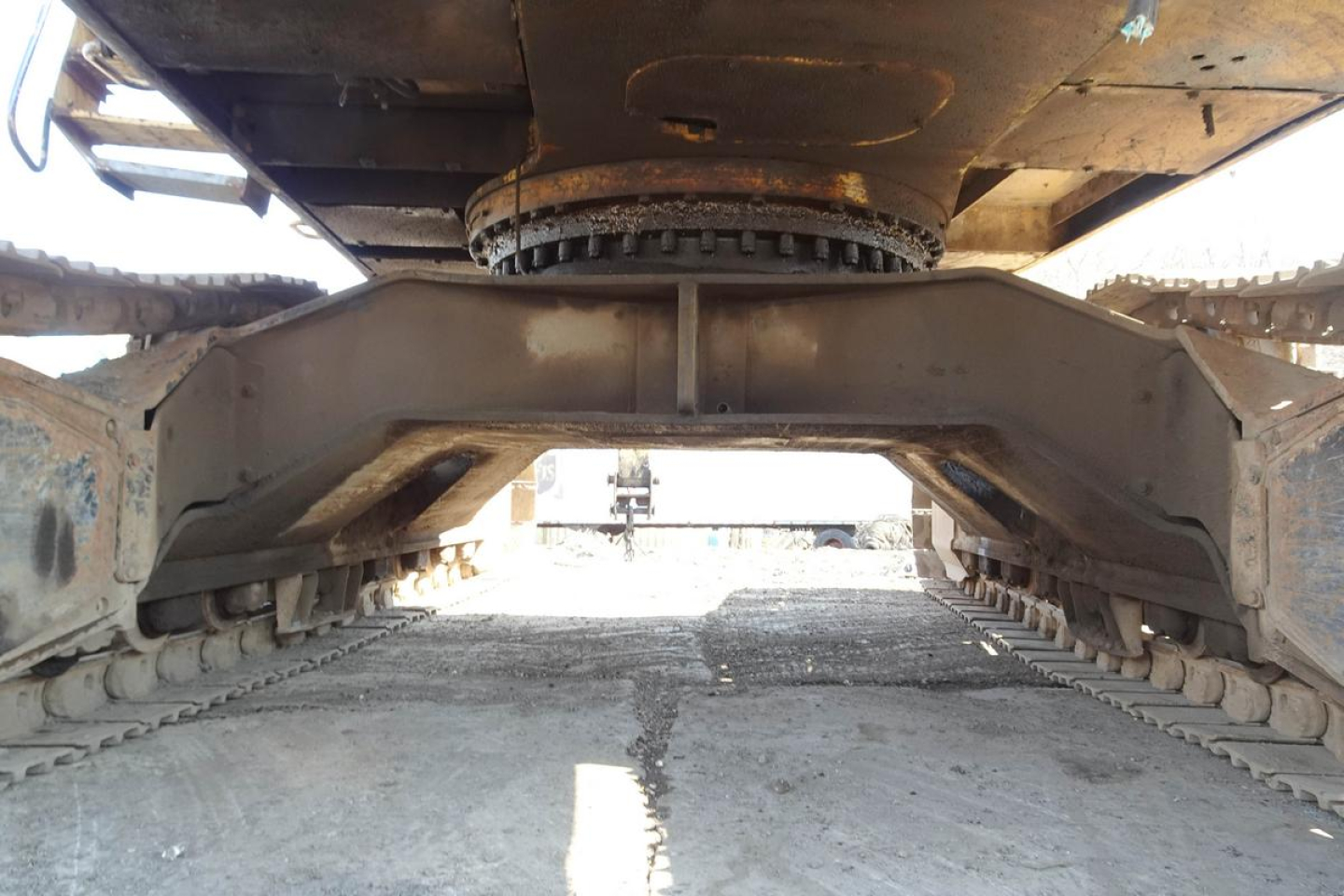 Underbelly view of a Caterpillar 330L MH excavator showing tracked undercarriage and central frame.