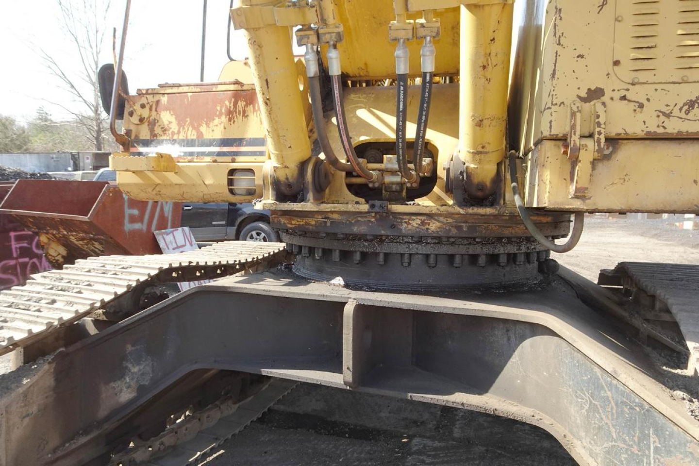 Caterpillar 330L MH undercarriage and hydraulic rotator mounting showing hydraulic lines and track shoes.