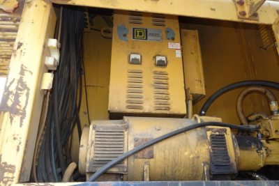 Caterpillar 330L MH machinery control panel and hydraulic motor area showing yellow body, labels, and wiring harness.