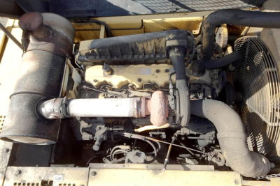 Caterpillar 330L MH engine bay showing intake, turbocharger, radiator fan, and exhaust system in a used trucking equipment.