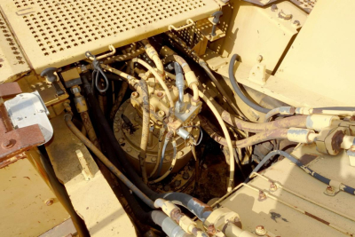 Caterpillar 330L MH engine bay showing hydraulic lines and fittings with yellow equipment, various hoses and components visible.