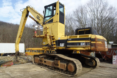 Caterpillar 330L MH excavator in service showing yellow and black body with tracks and long hydraulic arm.