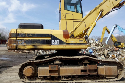 Caterpillar 330L MH tracked excavator in-garage view showing side profile with yellow body and CAT logo on cab and boom.