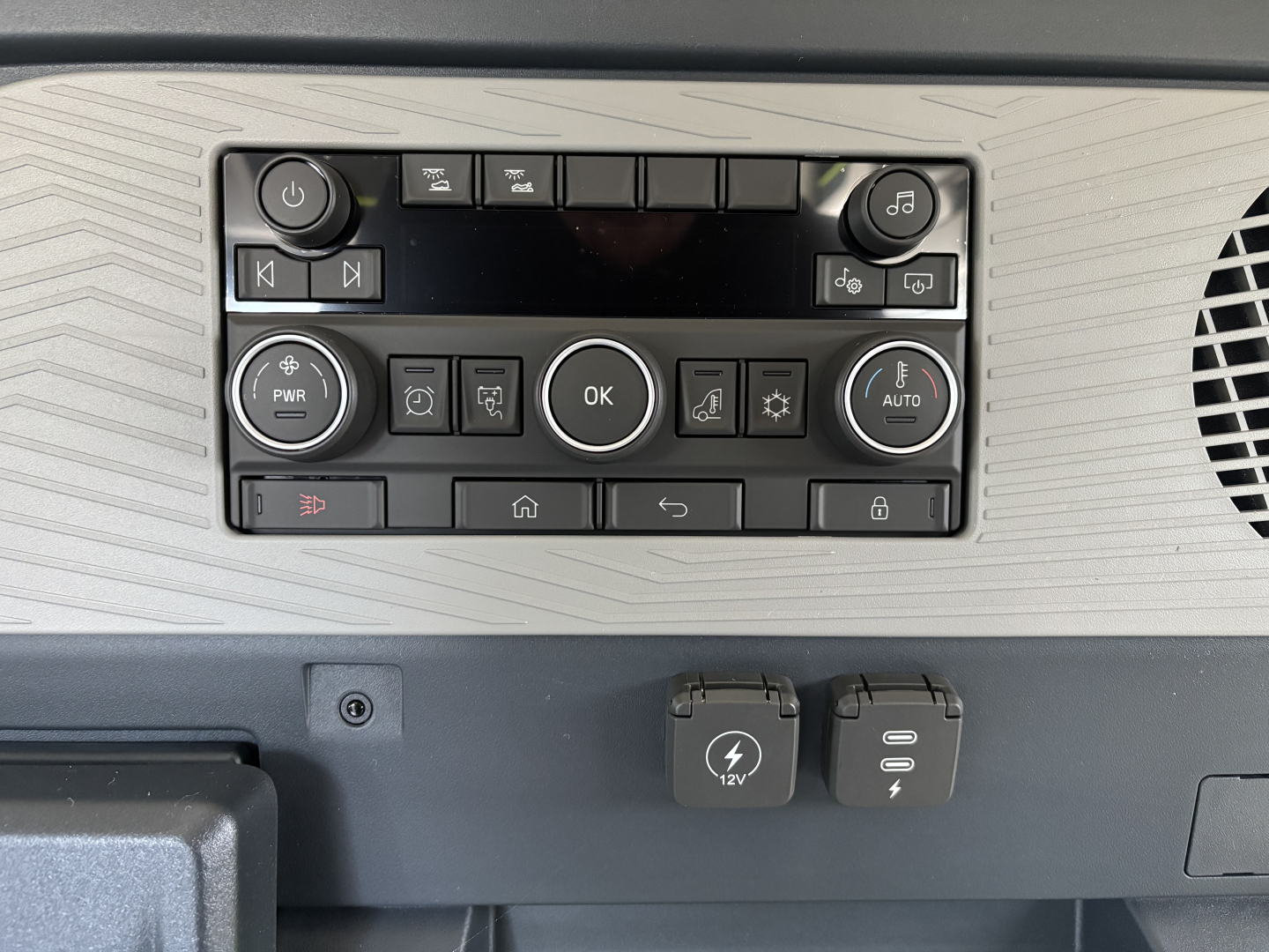 Volvo VNL64T640 dashboard control panel with circular OK button, climate controls, and power outlets; 12V DC and USB-C ports visible.