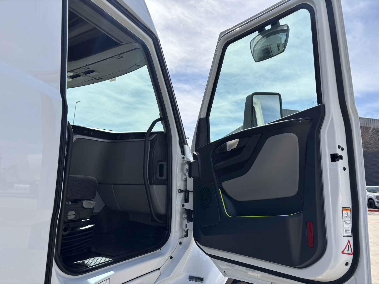 Volvo VNL64T640 sleeper cab interior with open door showing dashboard and entry area.