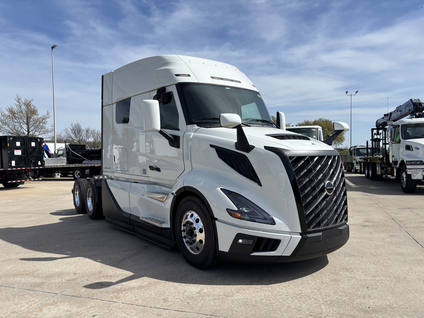 Volvo VNL64T640 truck in a showroom lot showing cab, chrome grille, and white exterior with sleeper compartment.