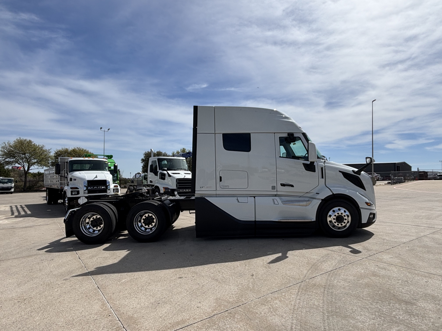 Volvo VNL64T640 truck tractor side view showing sleeper cab and dual rear axles with chrome wheels.