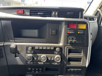 Volvo VNL dashboard showing climate controls and switch panel with red and yellow warning buttons.