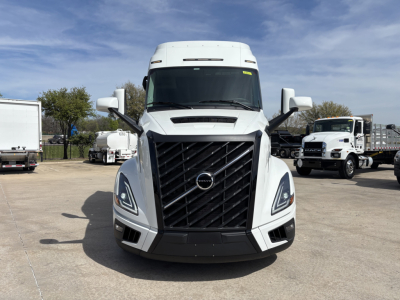 Front view of a white Volvo VNL truck with large black grille, headlights, and side mirrors visible.