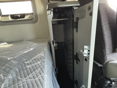 Volvo VNL64T640 cab interior showing driver area and doorway with storage cabinet and seat edge visible.