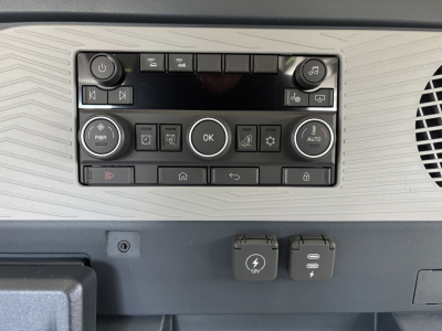 Volvo VNL64T640 dashboard control panel with circular OK button, climate controls, and power outlets; 12V DC and USB-C ports visible.