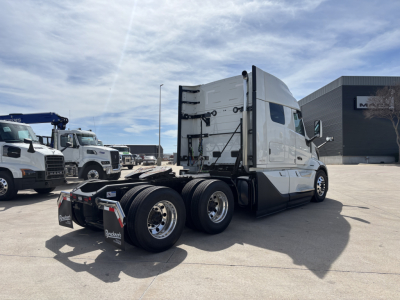 Semi truck tractor, rear view showing back of sleeper and dual rear axles, with chrome wheels and fifth wheel visible.