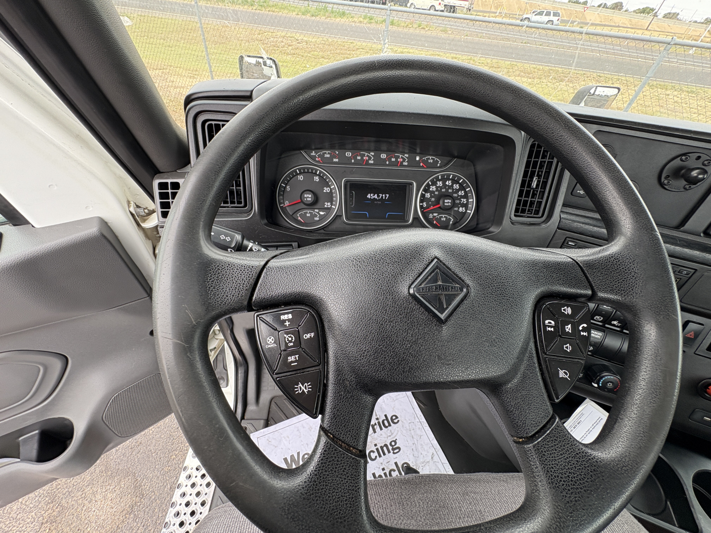 Steering wheel and instrument cluster of a 2021 International LT625 daycab truck interior, showing the left and right control stalks and gauge cluster.