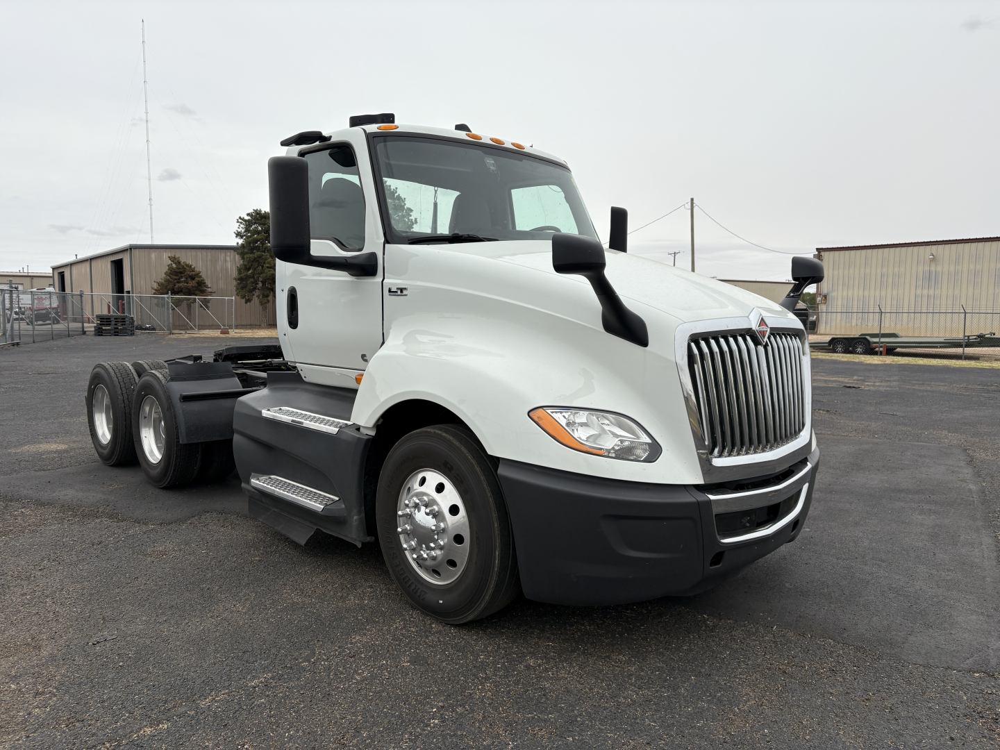 Truck cab with International LT625 branding showing front grille, side mirrors, and 6-wheel configuration; no visible text other than optional model badges.