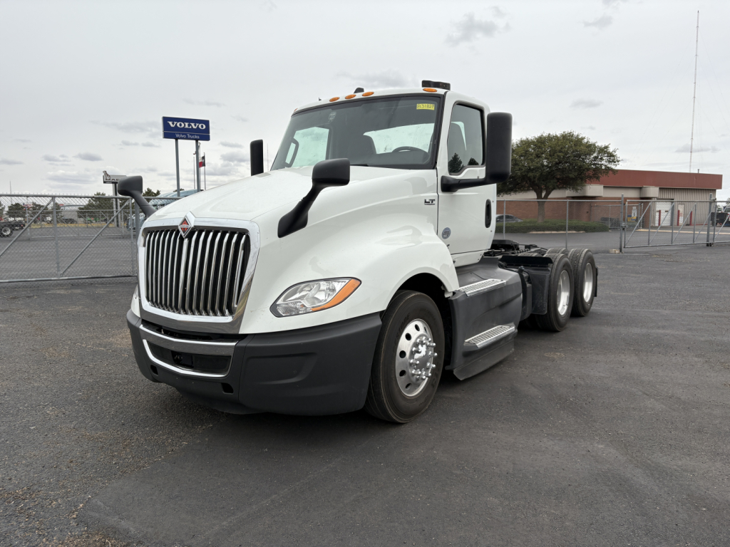 White 2021 International LT625 conventional daycab tractor front-left view showing chrome grille and dual rear axles.