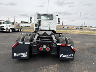 Rear view of a white 2021 International LT625 truck tractor showing dual rear axles, mud flaps with Bruckners logo, and red taillight hubs.