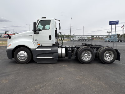 Truck side profile showing a white cab and chassis of a 2021 International LT625 with three axles and dual rear wheels.