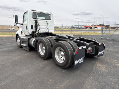 Truck chassis of a 2021 International LT625 daytime cab seen from rear three-quarter view; dual rear axles with black mud flaps showing 'BAXTER TRUCK GROUP' logos; spare wiring and fifth wheel area visible.