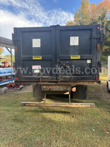 Rear view of a used 2013 Ford F-750 grapple truck with a black dump body and safety labels, stock number 41-97, VIN 3FRXF7FJ8DV028103.