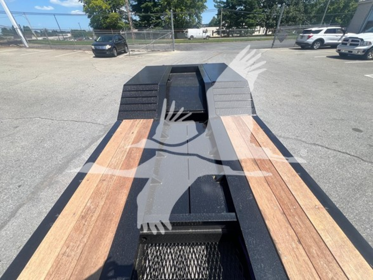 Lowboy trailer bed with wooden deck planks and black frame, showing front landing gear cutout and decking detail.