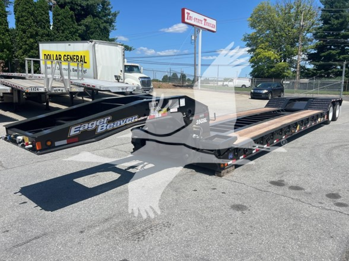Eager Beaver 35Gsl-S lowboy trailer showing long flatbed with dual axles and wheel ramps, in a dealership lot.