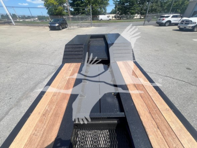 Lowboy trailer bed with wooden deck planks and black frame, showing front landing gear cutout and decking detail.