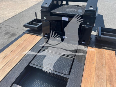 Trailer load deck with metal step and black hardware showing Eager Beaver branding and platform access step.