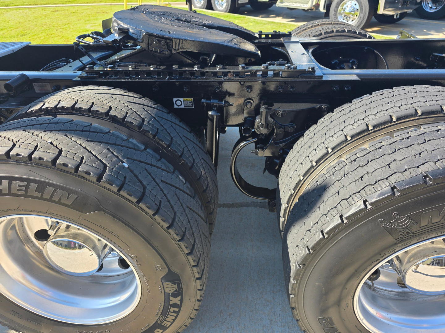 Kenworth T880 chassis showing dual rear axles with Michelin tires and silver wheels, undercarriage frame and fifth wheel area visible.