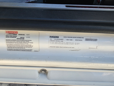 Kenworth T880 door jamb labels with VIN and PACCAR emissions info sticker; visible text includes brand labels and regulatory info.