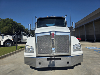 Kenworth T880 conventional daycab front view showing large chrome grille, bumper, and headlights; white cab with tall mirrors.