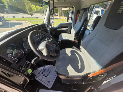 Kenworth T880 interior driver's seat and dashboard with steering wheel and gray fabric seats.