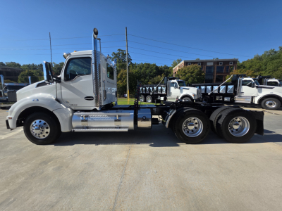 Kenworth T880 conventional daycab tractor in side view showing cab, exhaust stack, and rear trailer hitch with chrome steps.