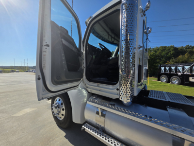 Kenworth T880 truck cab with open door and chrome steps, part of a conventional daycab tractor, showing entrance area and driver seat.