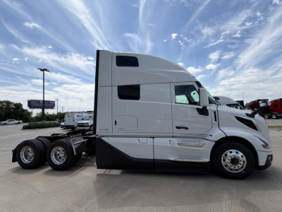 Volvo VNL64T860 truck side profile showing cab and tractor wheels in a dealership lot.
