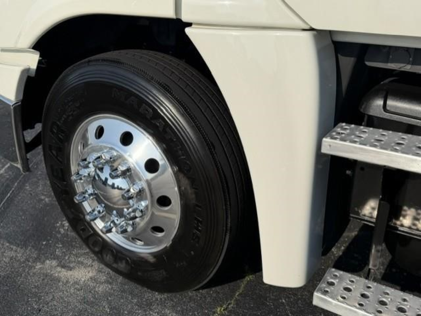 Freightliner Cascadia front wheel and fender showing aluminum wheel with hub and treaded tire.