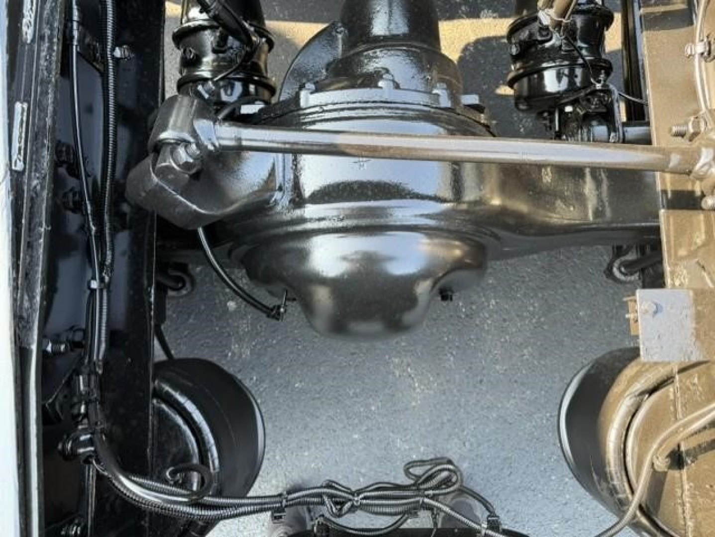 Drivetrain view showing axles and suspension on Freightliner Cascadia 126 drivetrain with visible universal joints and wiring harnesses.