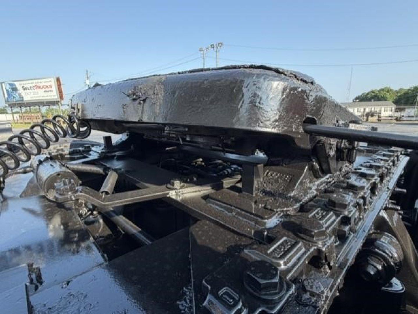 Freightliner Cascadia 126 truck chassis with raised air ride or electrical components and mountings visible on a glossy black frame.