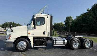 Truck chassis side view showing 2019 Freightliner Cascadia 126 day cab with triple rear axles and fuel tanks.