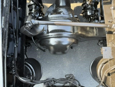 Drivetrain view showing axles and suspension on Freightliner Cascadia 126 drivetrain with visible universal joints and wiring harnesses.