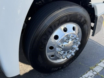 Goodyear tire with wheel on Freightliner Cascadia front, chrome hub, black tire with Goodyear lettering visible.