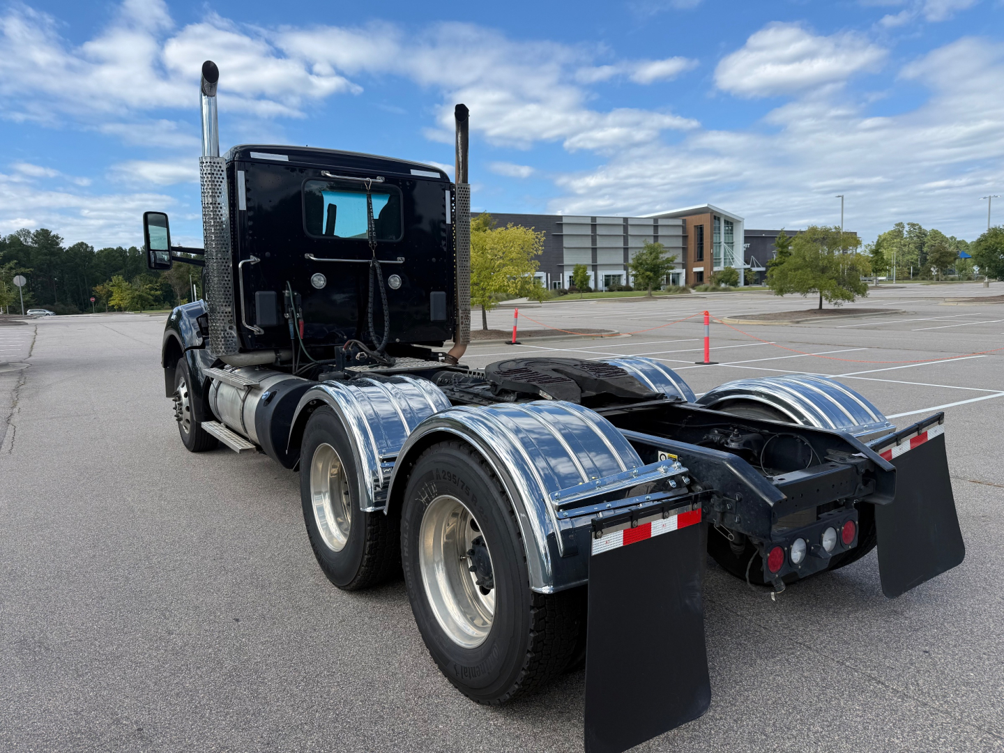 Kenworth T880 chassis and cab shown from rear-side, with dual rear axles and polished aluminum fenders.