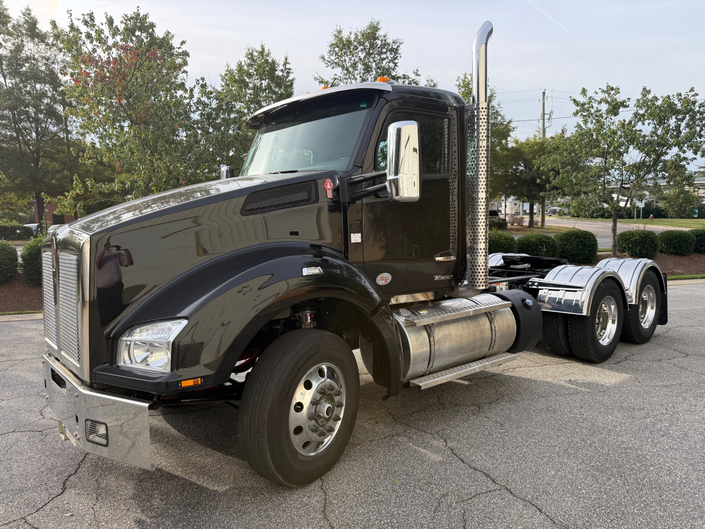 Kenworth T880 daycab truck in black, side view showing fuel tanks, chrome exhaust stack, front grille, and dual rear axles.
