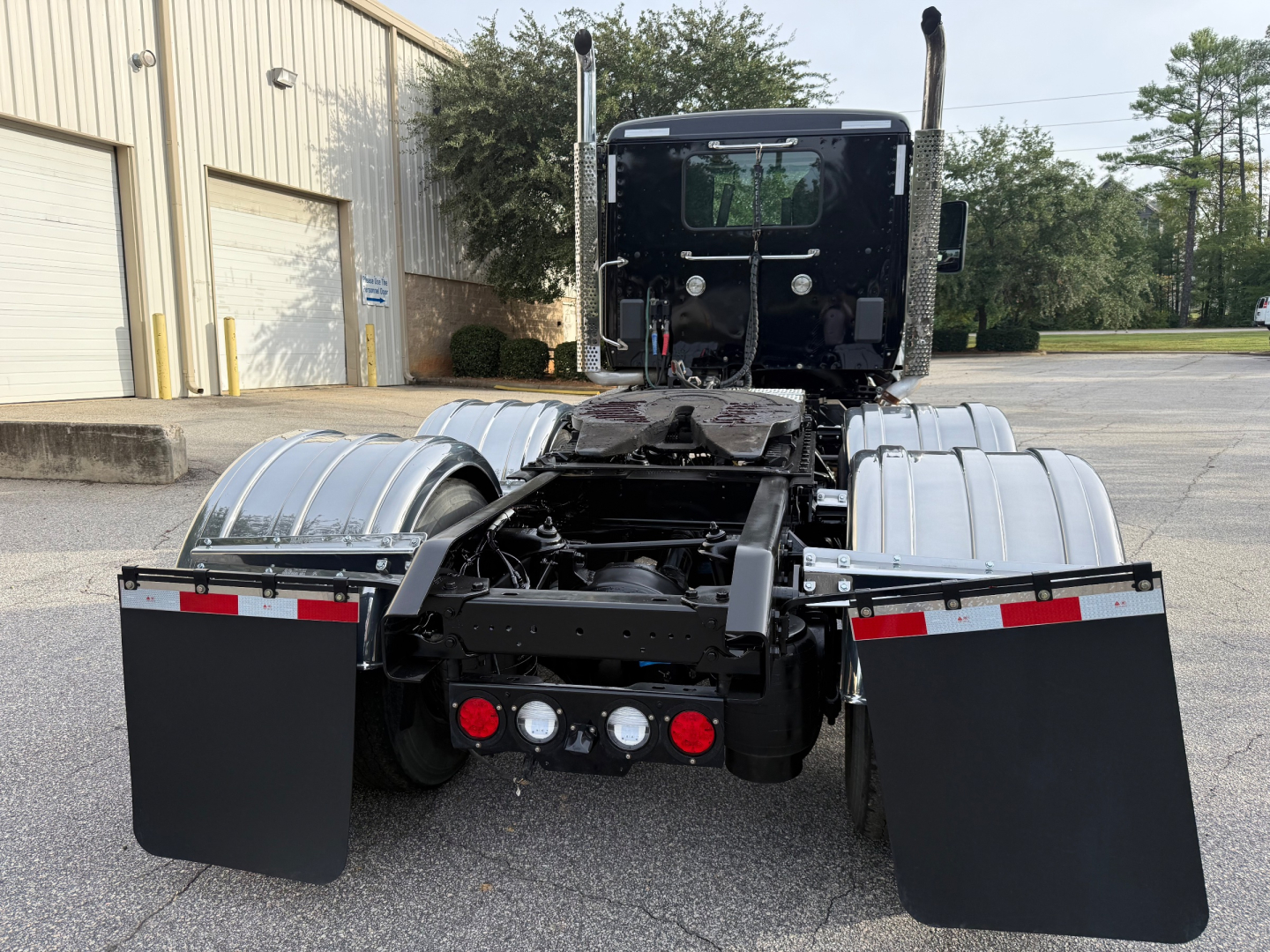 Kenworth T880 truck rear view showing chassis, fuel tanks, mud flaps, and rear lights with axles and fender panels.
