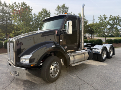Kenworth T880 daycab truck in black, side view showing fuel tanks, chrome exhaust stack, front grille, and dual rear axles.