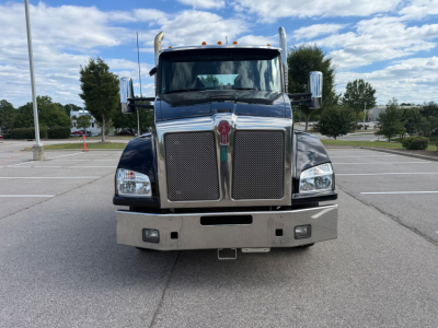 Kenworth T880 front view showing chrome grille, bumper, and dual headlights with large mirrors.