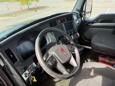 Kenworth T880 truck interior showing steering wheel, dashboard, and driver seat with center console and touchscreen display.