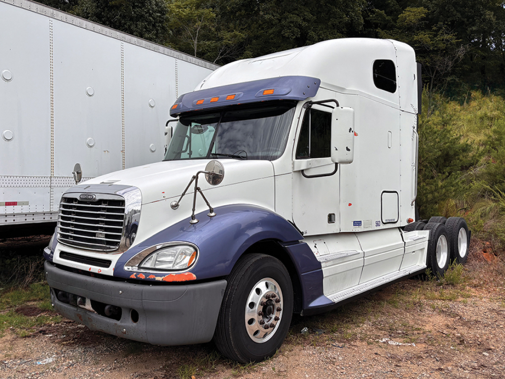 Truck image showing a white Freightliner CL120 Columbia with blue fenders, sleeper cab, and dual rear axles.